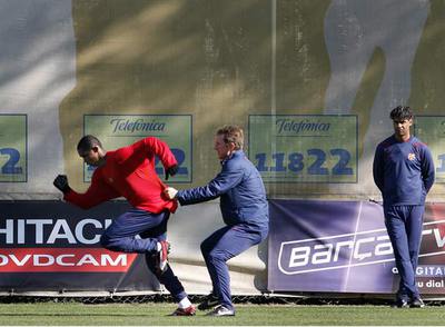Eto'o, con el preparador físico Albert Roca, y Frank Rijkaard a la expectativa, ayer en el entrenamiento.