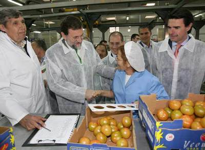 Mariano Rajoy saluda a una trabajadora de una empresa que comercializa tomates en Las Palmas. A la derecha, el presidente del PP de Canarias, José Manuel Soria.