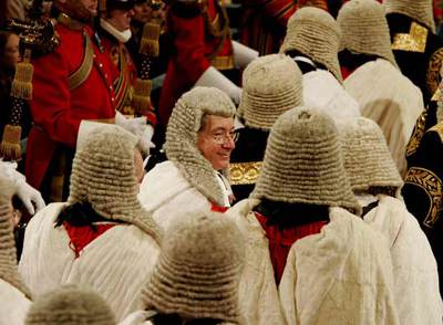 Varios lores, ataviados con peluca y traje ceremonial, aguardan en la Galería Real la sesión de apertura del Parlamento británico en 2004.
