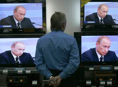 Un dependiente de una tienda de San Petersburgo sigue la intervención de ayer del presidente Putin.