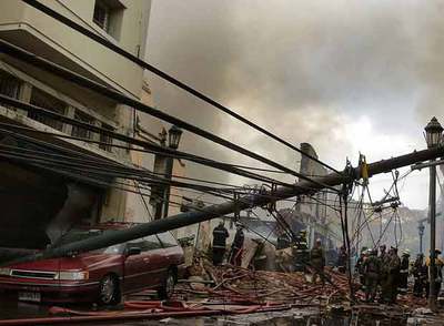 Un equipo de bomberos trabaja en el lugar de la explosión de gas, en el casco histórico de Valparaíso.