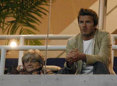Beckham, en un palco junto a su madre, Sandra, observa el juego.