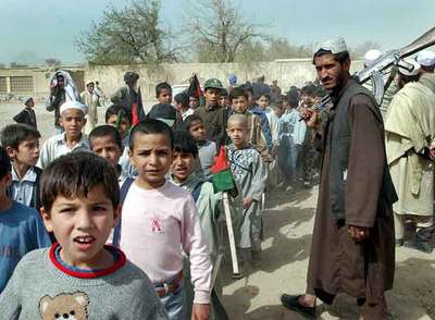 Niños de Kandahar protegidos por civiles armados asisten a una reunión para pedir educación para todos.