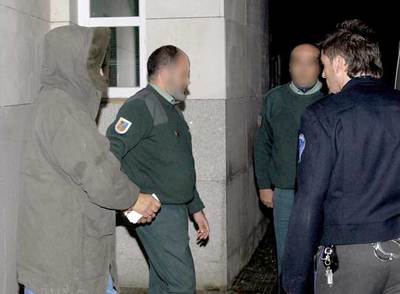 Santiago Mainar (izquierda) sale esposado del juzgado de Jaca camino de la cárcel.