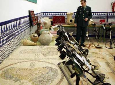 Un guardia civil custodia las piezas saqueadas.