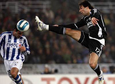 Garrido cabecea el balón ante la entrada, con el pie levantado, de Van Nistelrooy.