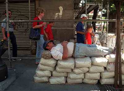 Un obrero de la construcción echa una siesta en la calle Mayor de Madrid.