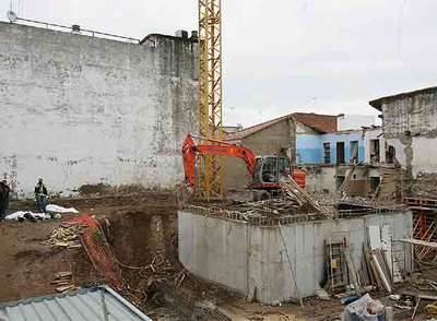 La vivienda siniestrada y, a la izquierda, los cuerpos de las dos víctimas mortales.