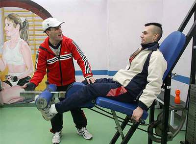 José Abrodes,  Brother,  da instrucciones a un compañero en una máquina de pesas.