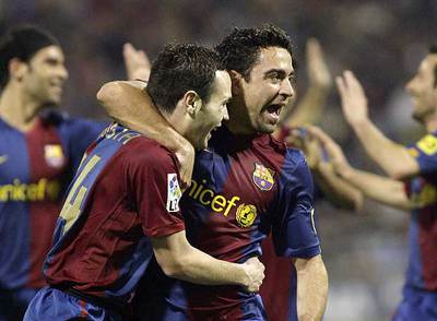 Iniesta y Xavi se abrazan tras el segundo gol al Zaragoza.