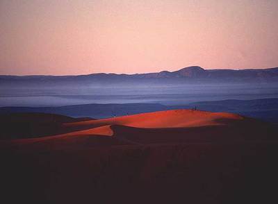 Amanecer en las dunas de Merzouga, al sur de Marruecos; al fondo, la cordillera del Atlas.