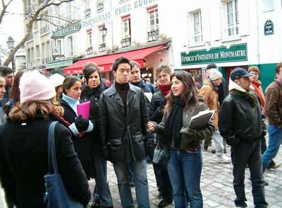 Una vecina de Montmartre, en París, ejerce de guía voluntaria del Club International para enseñar su barrio a un grupo de turistas.