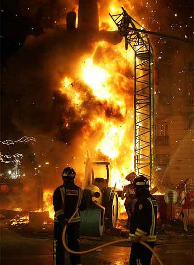 Los bomberos controlan la quema de unas de las 768 fallas que anoche ardieron en Valencia.