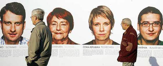 Dos hombres observan los retratos de ciudadanos de cada uno de los 27 Estados miembros expuestos en Berlín con motivo del 50º aniversario de la UE.