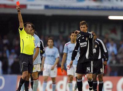 Pérez Burrull muestra la tarjeta roja de expulsión a un Guti contrariado.