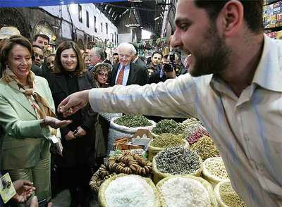 Un vendedor regala unas nueces a Nancy Pelosi durante su visita ayer a un mercado de Damasco.