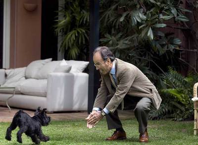 Santiago Dexeus juega con  Chunga,  su perra, en el jardín de su casa.