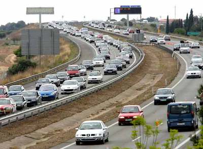 Caravana de vehículos a mediodía en la AP-7, en sentido Barcelona, a su paso por la localidad tarraconense de Salou.