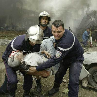 Los bomberos evacuan a una víctima del coche bomba que estalló ayer en pleno centro de Argel.