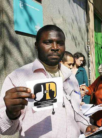 Un inmigrante muestra propaganda con su reclamación de voto.