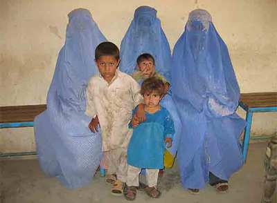 Tres mujeres afganas, vestidas con el burka, y sus hijos, de regreso a su país.