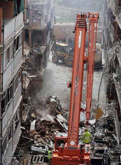 A la izquierda, el trabajo de las máquinas de desescombro.