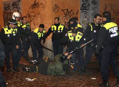 Un grupo de policías municipales rodea a un joven caído en el suelo, al que intenta quitar una muleta, en la confluencia de la calle de la Palma y Corredera Alta de San Pablo.