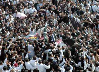 El jefe del Tribunal Supremo paquistaní, Iftikhar Chaudhry, saluda desde su vehículo al llegar a  Lahore.