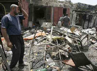 Un hombre mira las ruinas de su tienda, destruida ayer por un coche bomba que mató a 35 personas en Bagdad.