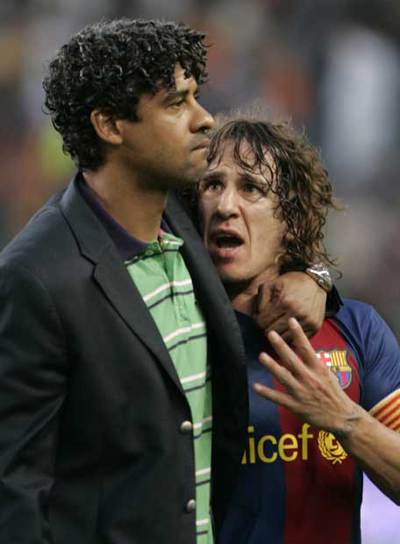 Rijkaard consuela a Puyol al término del partido.
