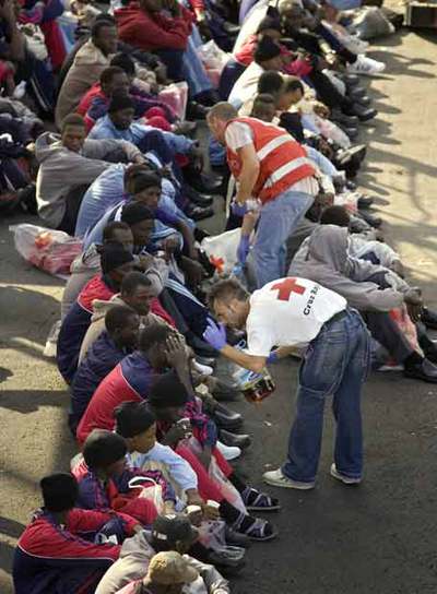 Miembros de la Cruz Roja atienden a algunos de los inmigrantes en el puerto de Los Cristianos.