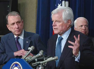 El demócrata Edward Kennedy explica a la prensa el acuerdo, con el republicano John McCain a su espalda.