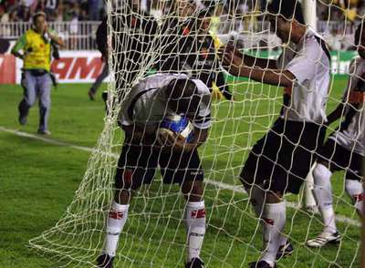Romario besa el balón mientras un compañero corre a abrazarle.