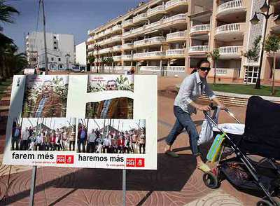 Cartel electoral del candidato socialista en Moncofa en un paseo junto a un bloque de viendas.