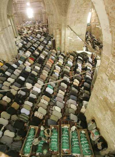 Rezo en Gaza junto a los cuerpos de víctimas de un bombardeo.