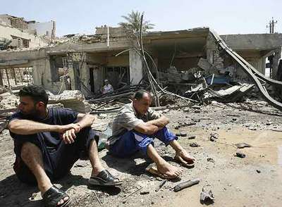Dos iraquíes sentados ante sus casas destruidas por una bomba ayer en Bagdad.