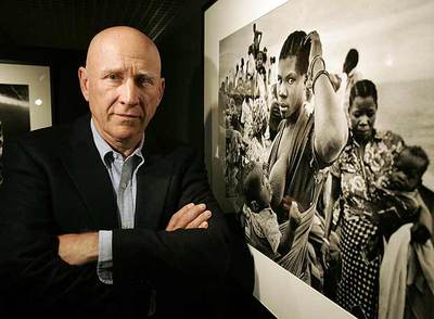 Sebastião Salgado posa junto a una de sus fotografías ayer en Madrid.