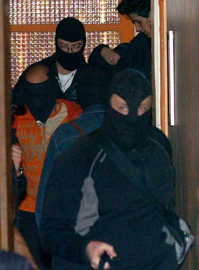 Aitor Lorente (en el medio)  abandona su casa custodiado por dos policías.