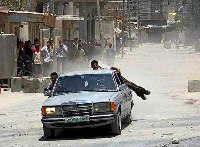 Un grupo de palestinos transporta a un herido durante la lucha entre militantes de Al Fatah y de Hamás en la ciudad de Gaza.
