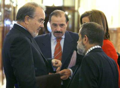Solbes, a la izquierda, con el diputado del PP Vicente Martínez Pujalte, de frente, ayer en el Congreso.