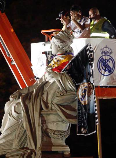 Raúl aplaude tras colocar la bandera en el hombro de la Cibeles.