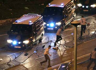 Aficionados madridistas huyen de la policía el domingo por la noche cerca de Cibeles.
