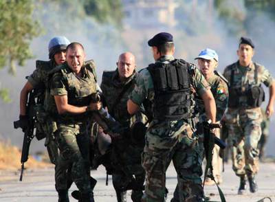 Soldados españoles trasladan a una de las víctimas del ataque con coche bomba en el pueblo de Jiam, al sur de Líbano.