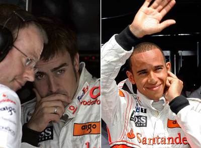 Fernando Alonso, junto a un miembro de su equipo, en su  box  tras sufrir las dos averías. Hamilton, a la derecha, saluda a los aficionados.