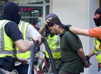 Guardias civiles introducen en un coche al supuesto grapo Israel Clemente a principios del pasado junio tras registrar un piso en Barcelona.