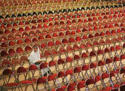 Una estudiante iraní espera en una boda multitudinaria financiada por organizaciones para ayudar a los que no se pueden costear la ceremonia.