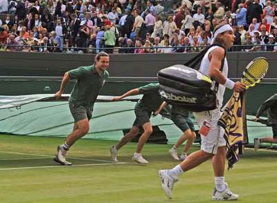 Rafael Nadal abandona la pista cuando el partido fue suspendido en el quinto  set. 