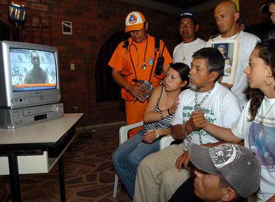 Gustavo Moncayo (centro) observa junto a familiares y amigos el vídeo en el que aparece su hijo Pablo, rehén de las FARC, la noche del martes en Palmira.