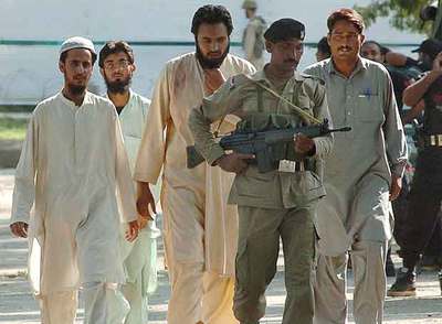 Un soldado escolta a estudiantes religiosos radicales que se atrincheraban en la Mezquita Roja de Islamabad.