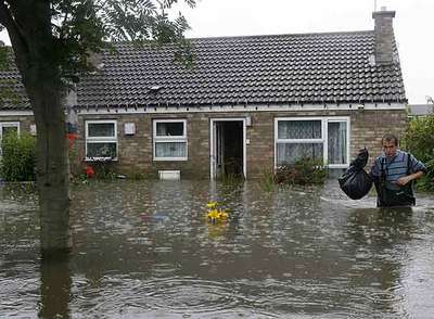 Una persona saca sus pertenencias de una vivienda inundada en la localidad de Toll Bar, en el norte de Inglaterra.